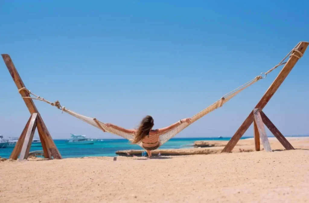 Woman relaxing in a beach hammock overlooking the crystal-clear Red Sea during a vacation in Egypt in November.