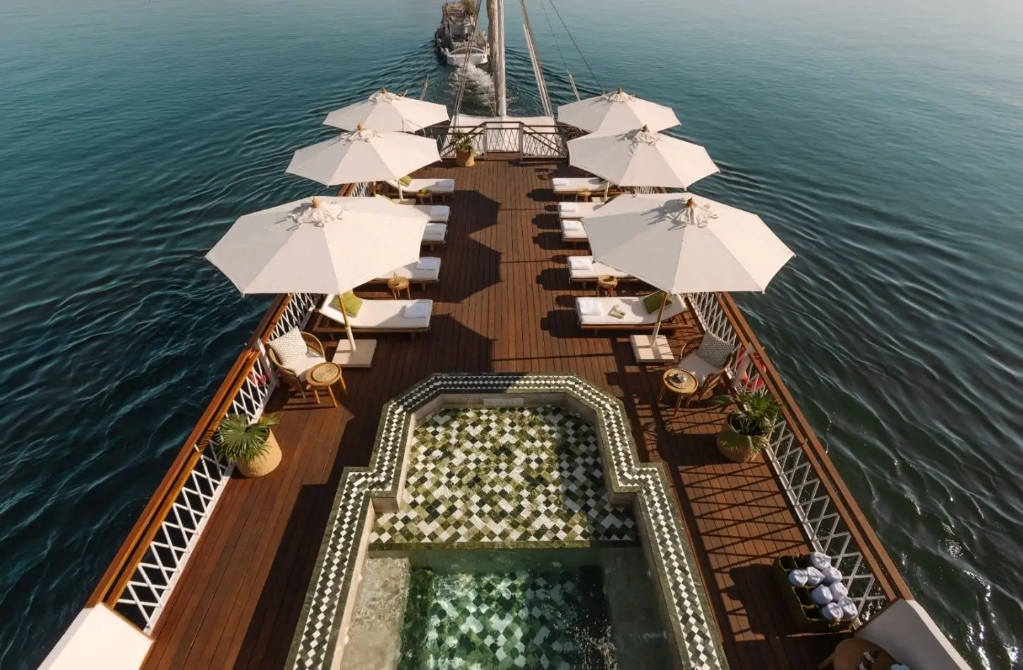 Aerial view of the wooden open deck and hot tub on a luxury Dahabiya sailboat, ideal for travelers comparing a Nile Cruise vs Dahabiya experience.