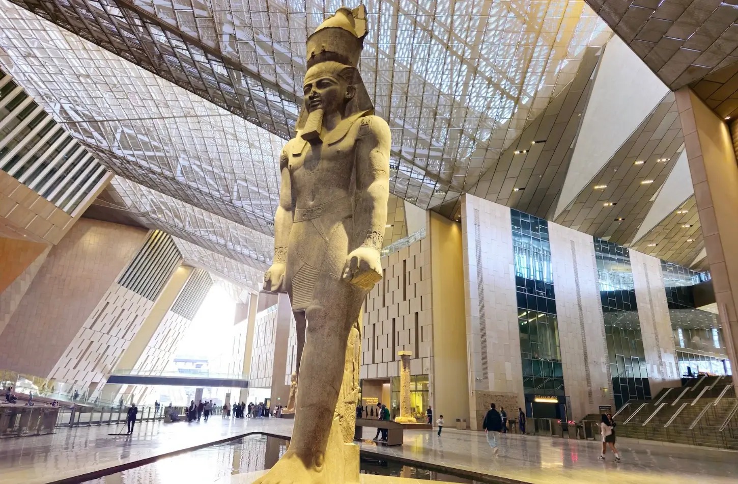 The colossal statue of Ramses the Great standing in the grand atrium of the Grand Egyptian Museum.